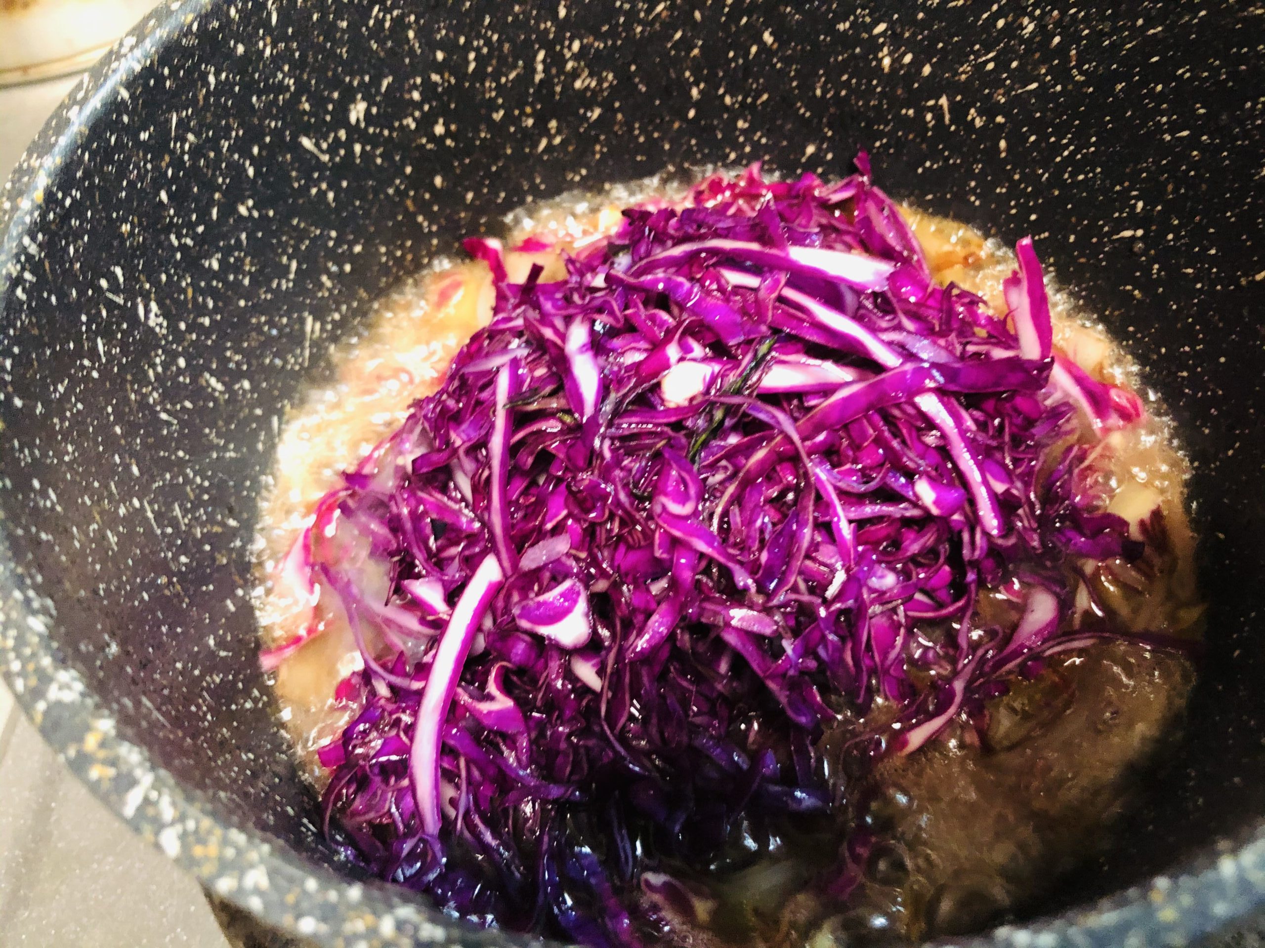 小鍋に塩もみした紫キャベツを入れる様子の画像です