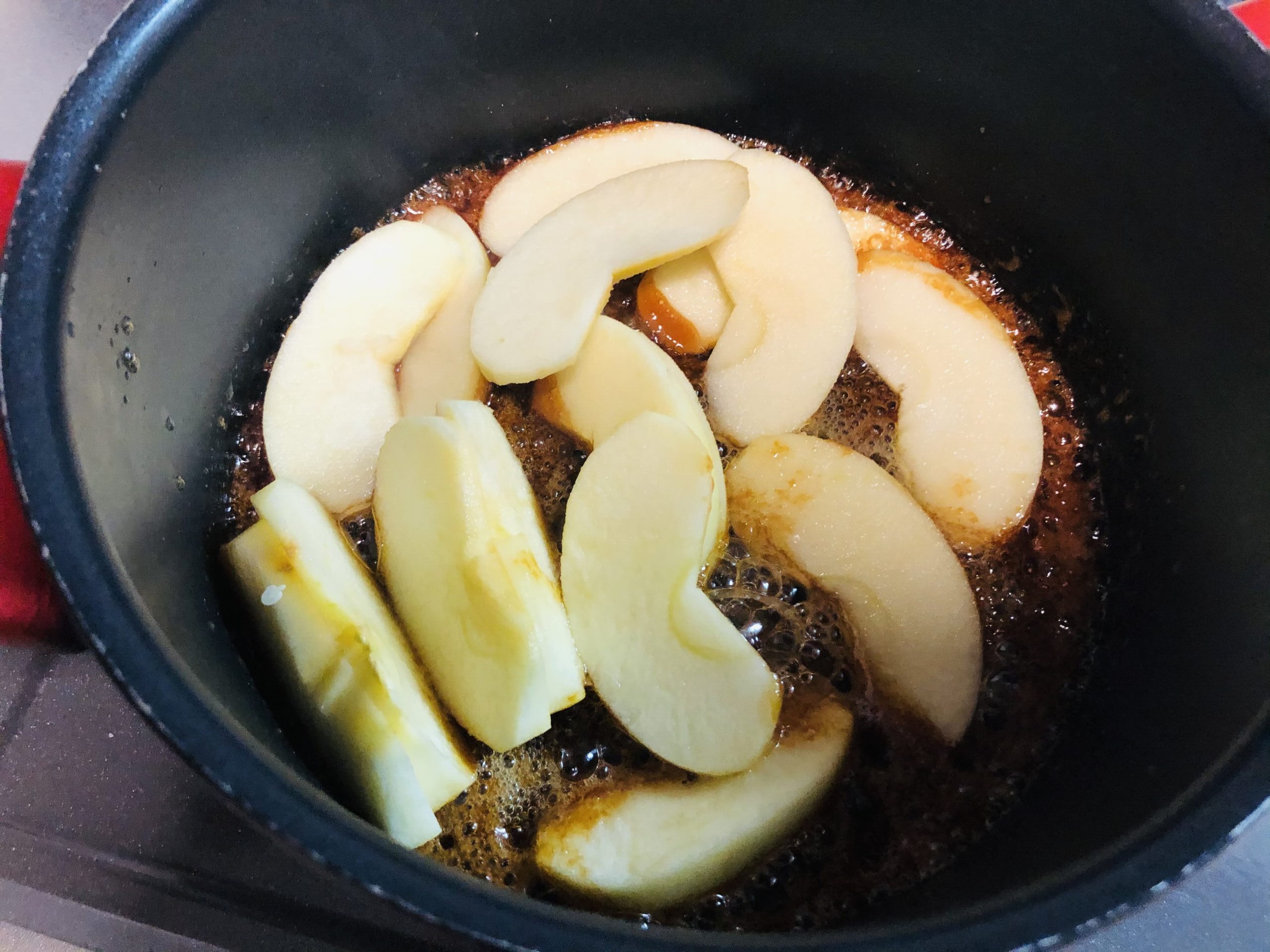 キャラメル状になった鍋にカットしたリンゴを入れた様子のがぞうです