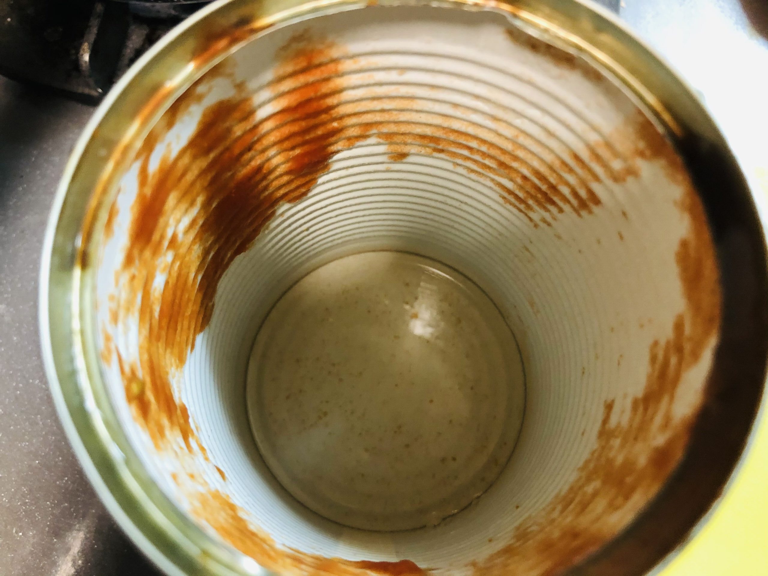 トマト缶に残ったトマトも水ですすいで鍋に入れる画像です。