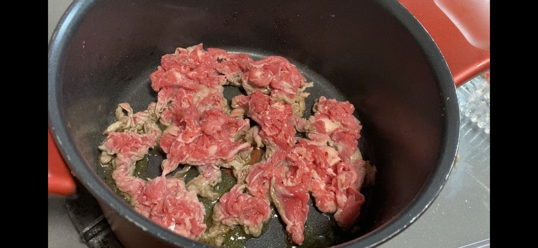 下味をつけた牛細切れ肉を広げながら、オリーブオイルで焼いていく様子の画像です