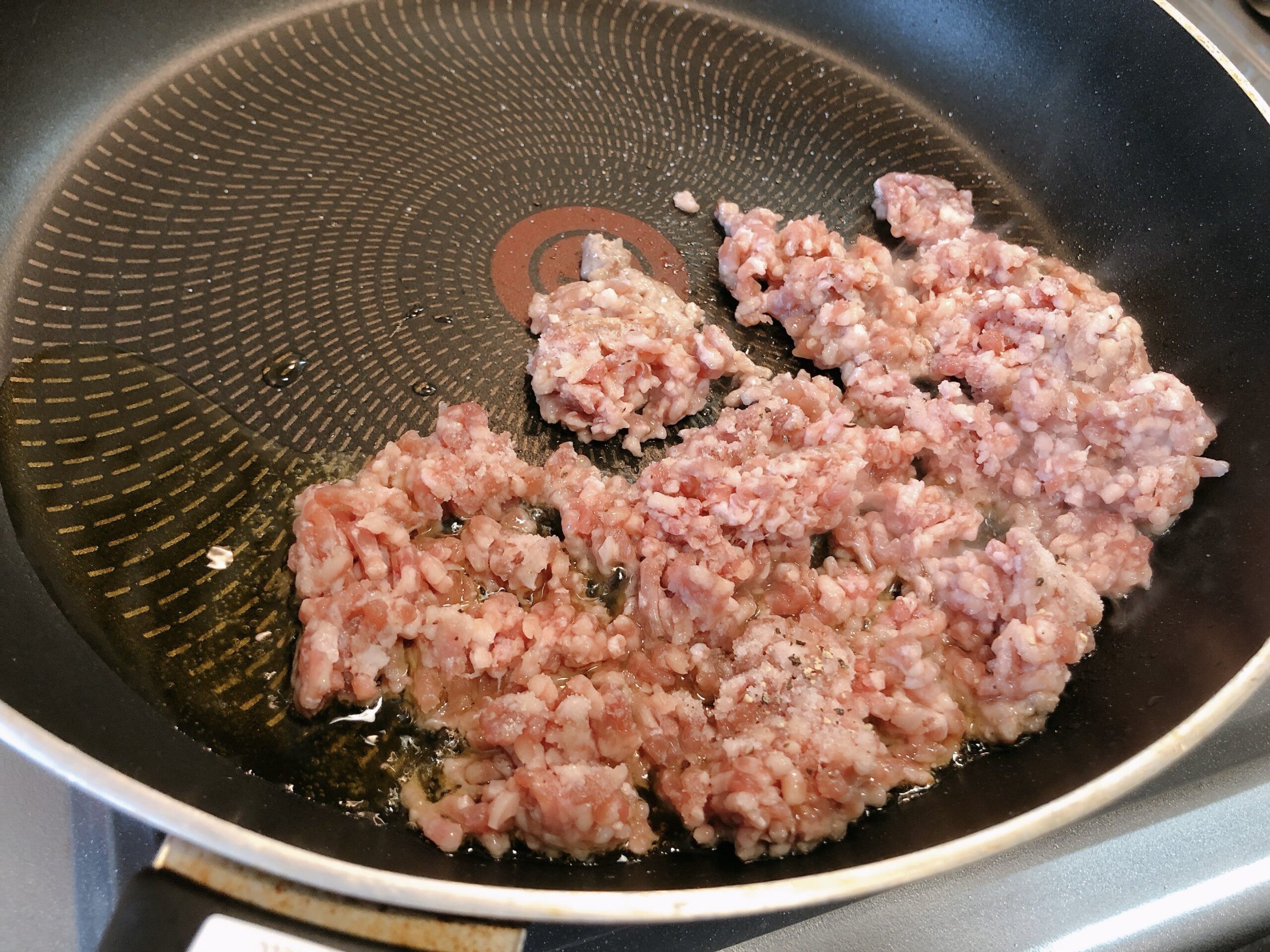 熱したフライパンにミンチ肉を入れた状態の画像です。