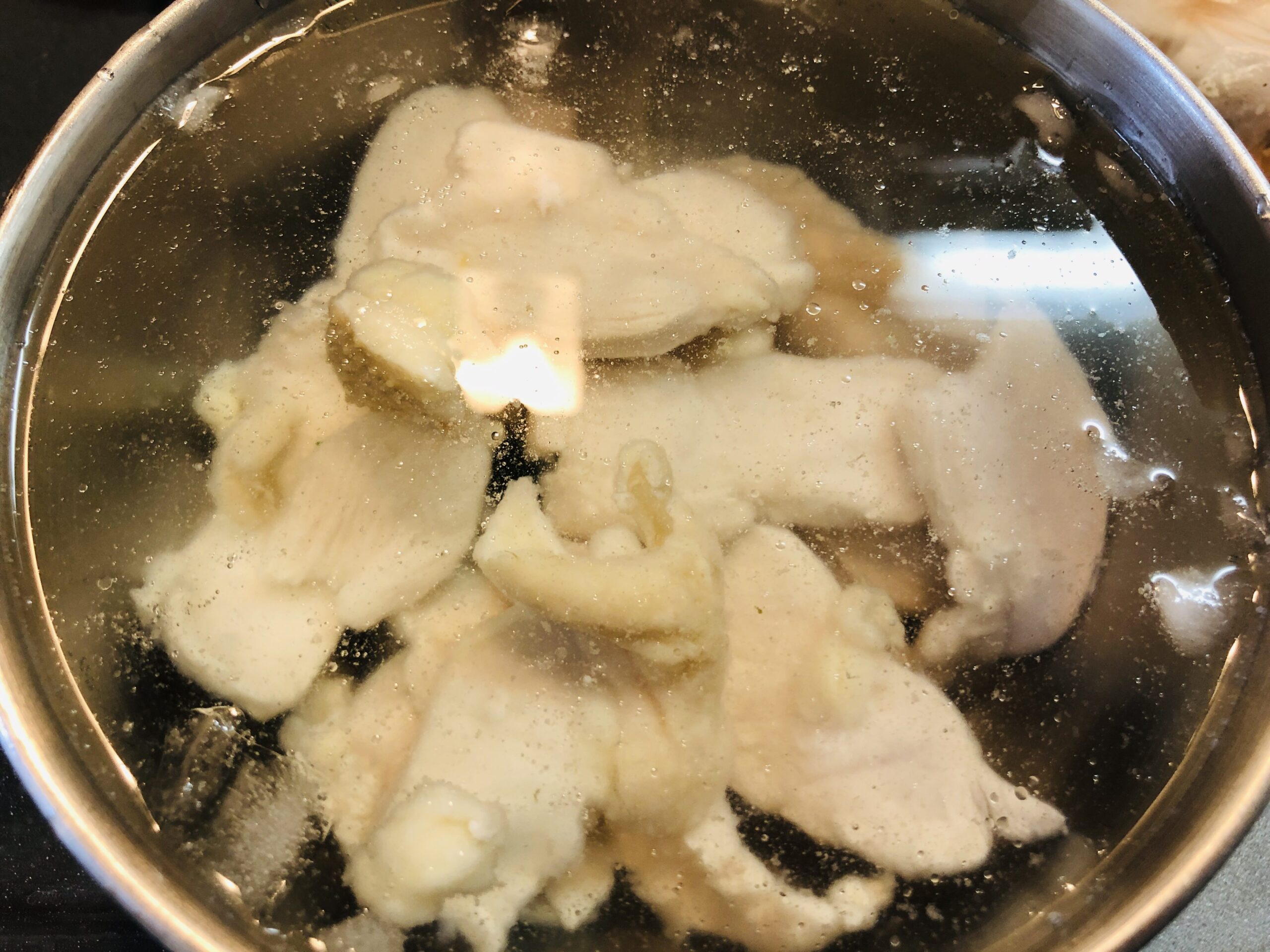 塩ゆでした鶏むね肉を氷水で冷やしている状態の画像です