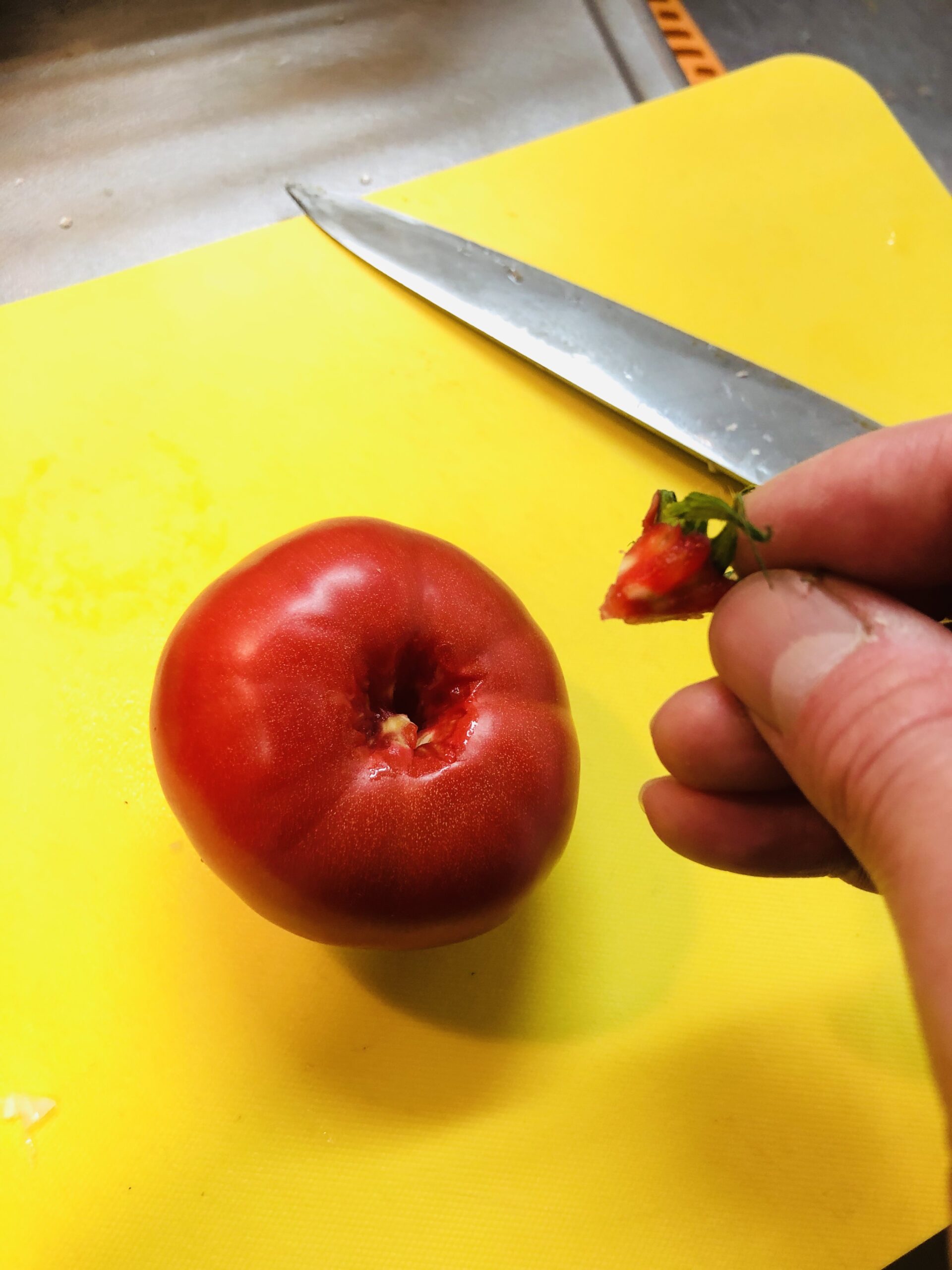 包丁でトマトのヘタと芯をくり抜いた状態の画像です