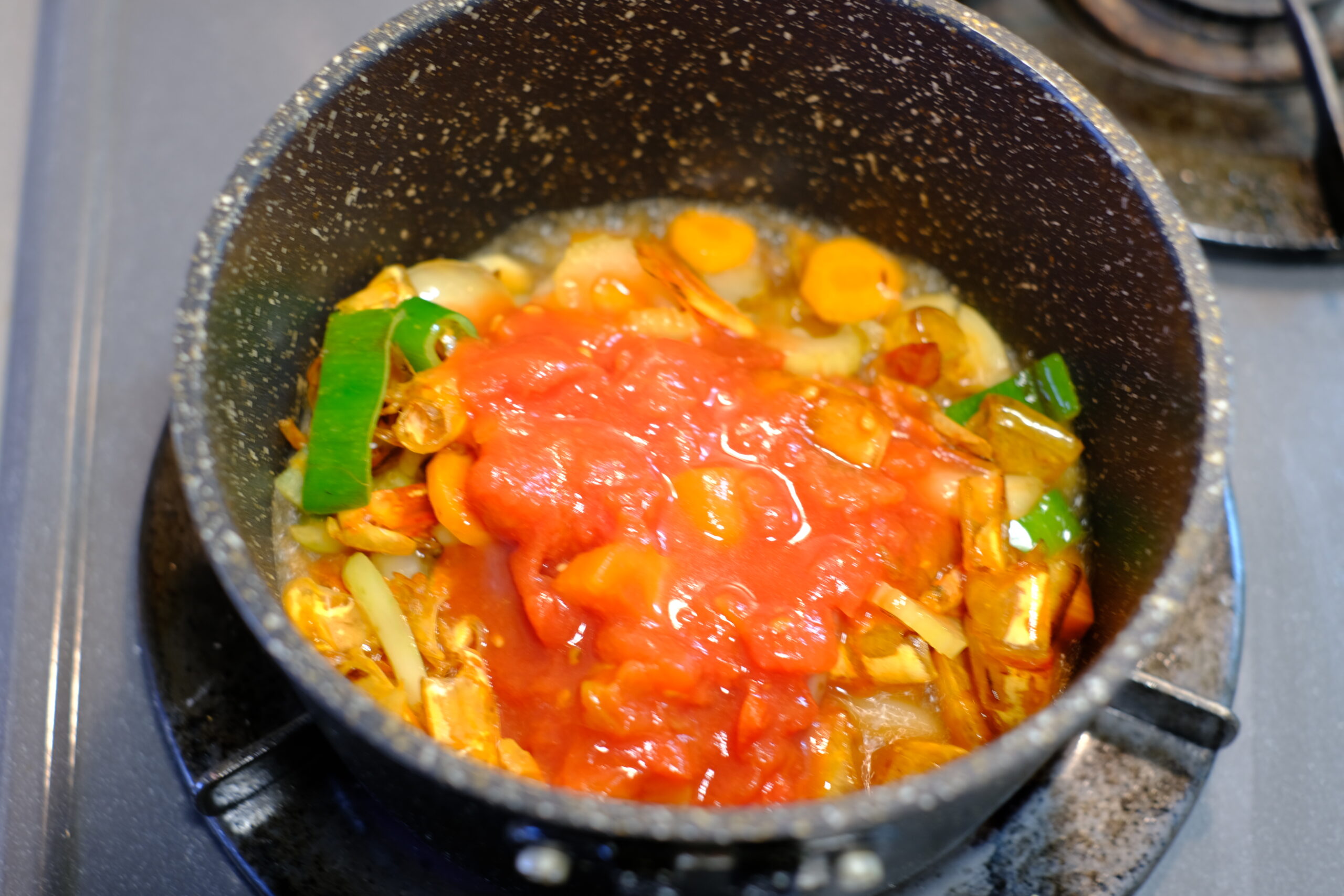 海老のソースを作る鍋にホールトマトを加えた状態の画像