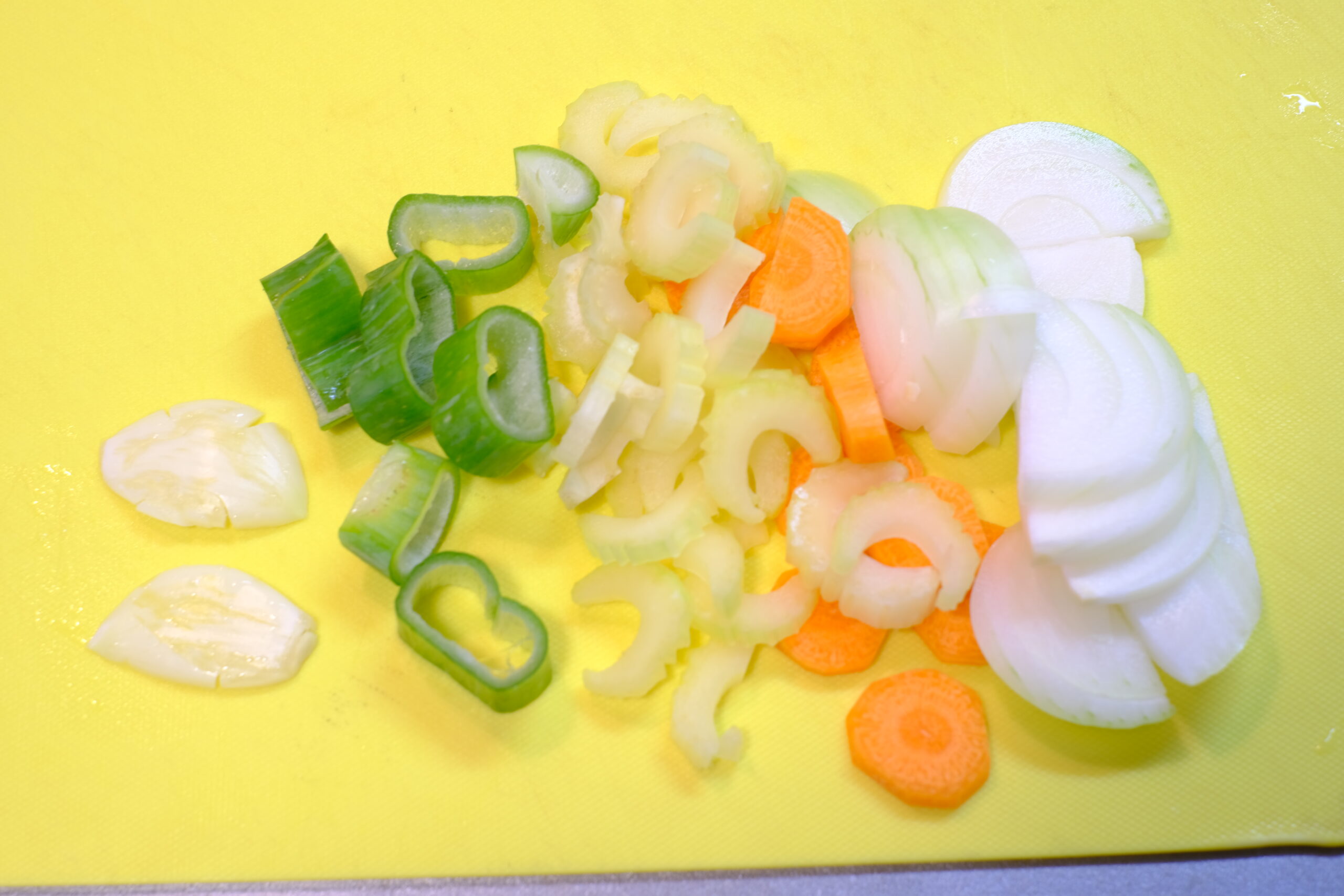 潰したニンニクとスライスした端材野菜の画像です